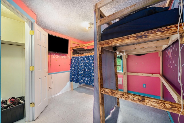 tiled bedroom featuring a textured ceiling