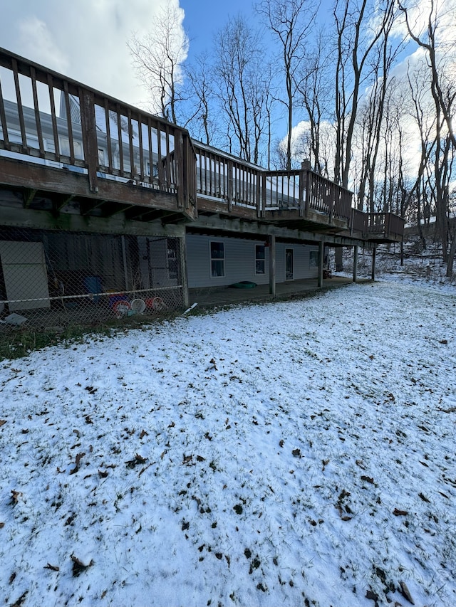 snow covered back of property featuring a wooden deck