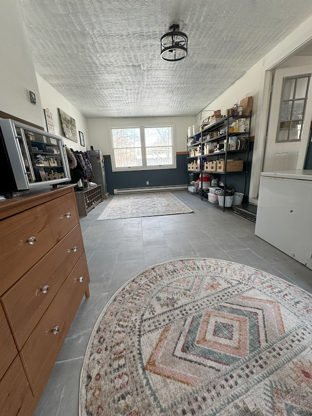 interior space with light tile patterned floors, a textured ceiling, and baseboard heating