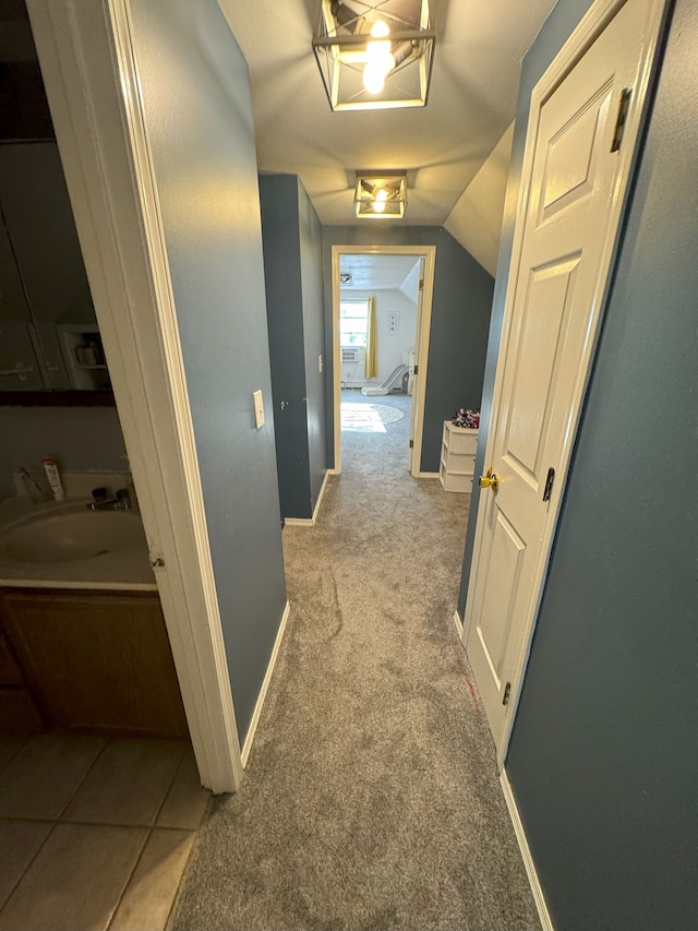 hallway featuring light carpet, sink, and vaulted ceiling