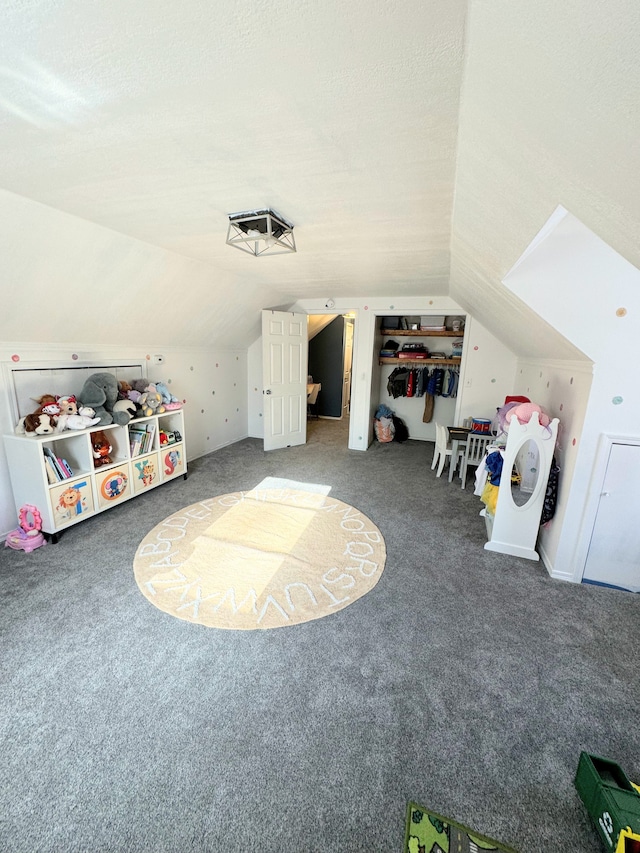 game room featuring a textured ceiling, carpet floors, and vaulted ceiling