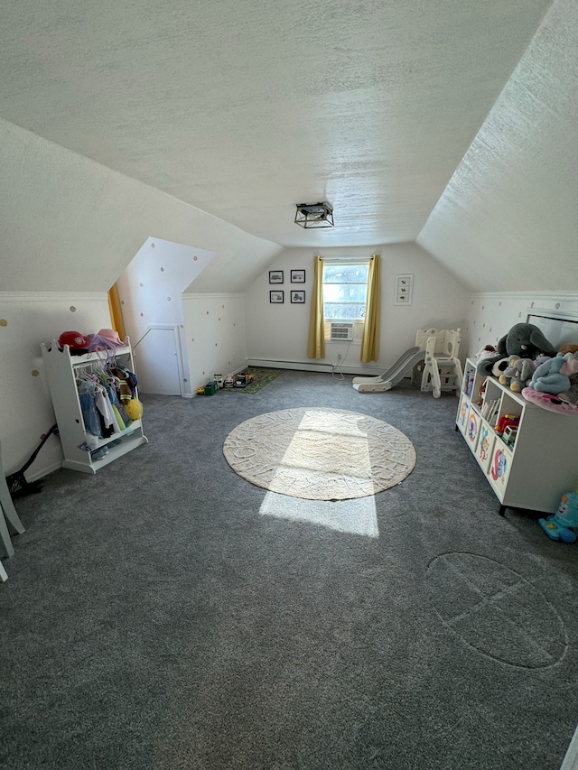 additional living space featuring a textured ceiling, dark carpet, and lofted ceiling