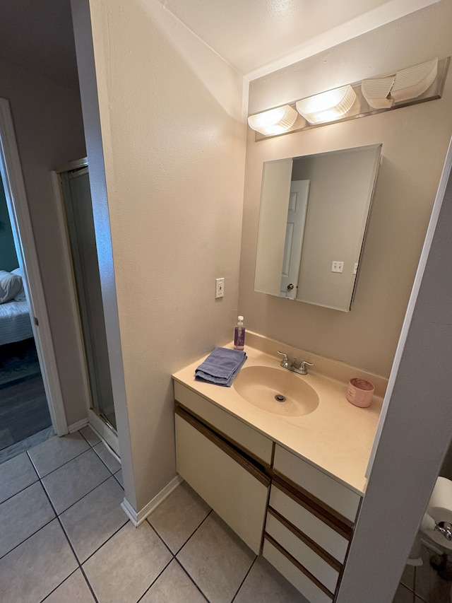 bathroom with tile patterned flooring, vanity, and a shower with shower door