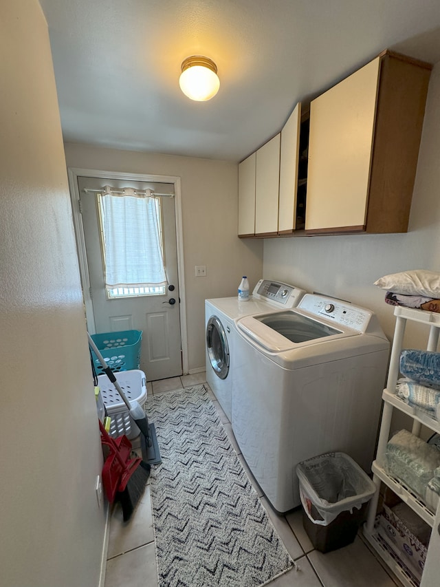 washroom with cabinets, independent washer and dryer, and light tile patterned flooring