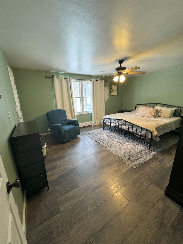 bedroom with ceiling fan, dark wood-type flooring, and a textured ceiling