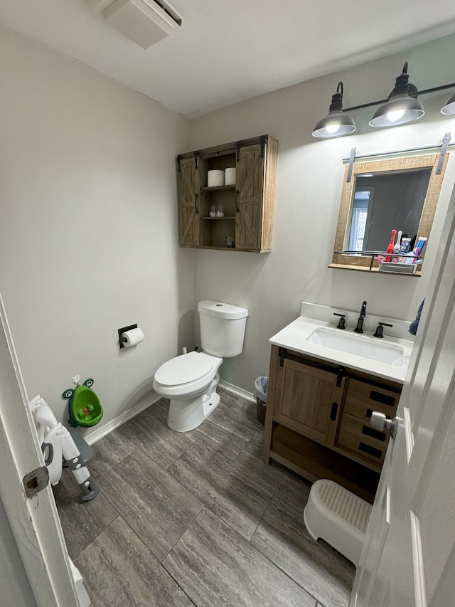 bathroom with hardwood / wood-style floors, vanity, and toilet