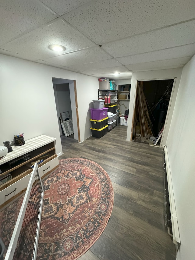 interior space featuring baseboard heating, a paneled ceiling, and dark hardwood / wood-style floors