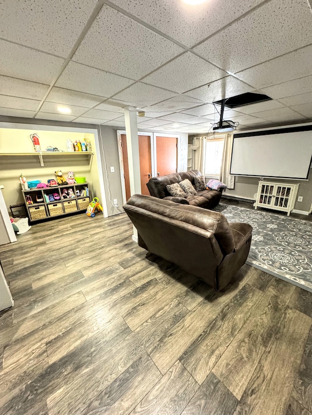 living room with ceiling fan, a drop ceiling, and hardwood / wood-style flooring