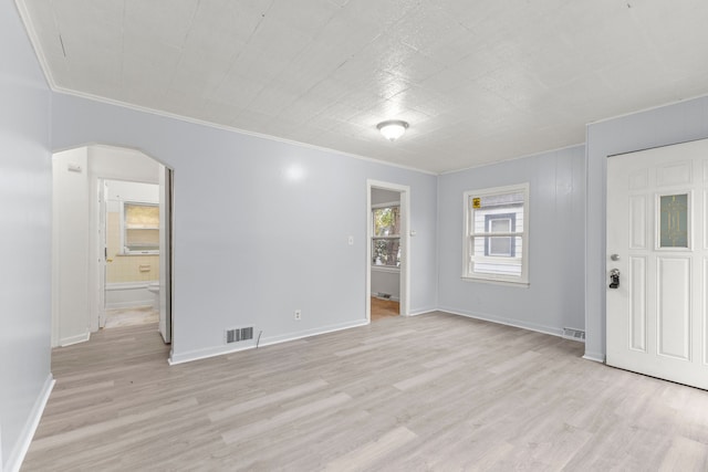 unfurnished room featuring ornamental molding and light wood-type flooring