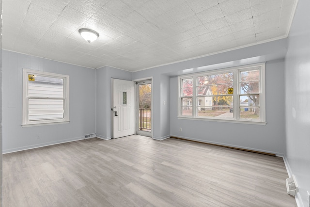 unfurnished room featuring light hardwood / wood-style floors and crown molding