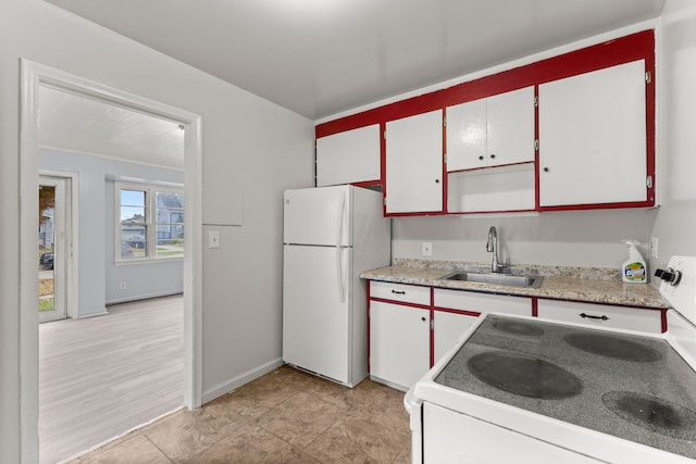 kitchen featuring white cabinetry, sink, light hardwood / wood-style floors, and white appliances