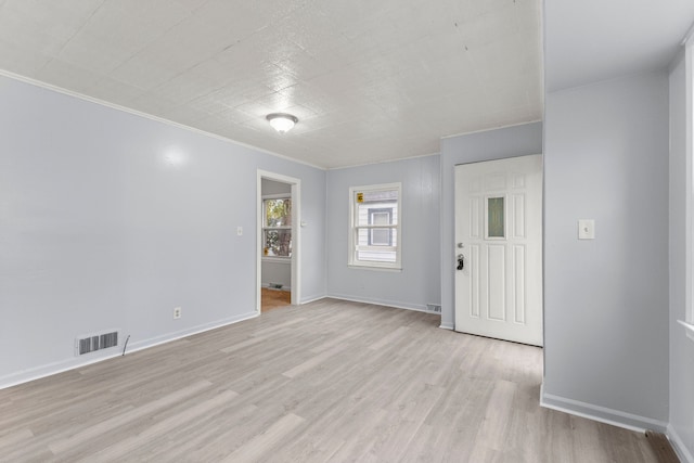 spare room featuring light hardwood / wood-style floors and ornamental molding