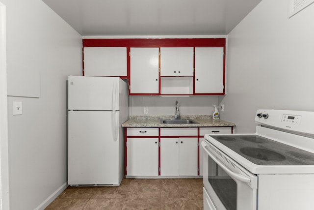 kitchen with white appliances, white cabinetry, and sink