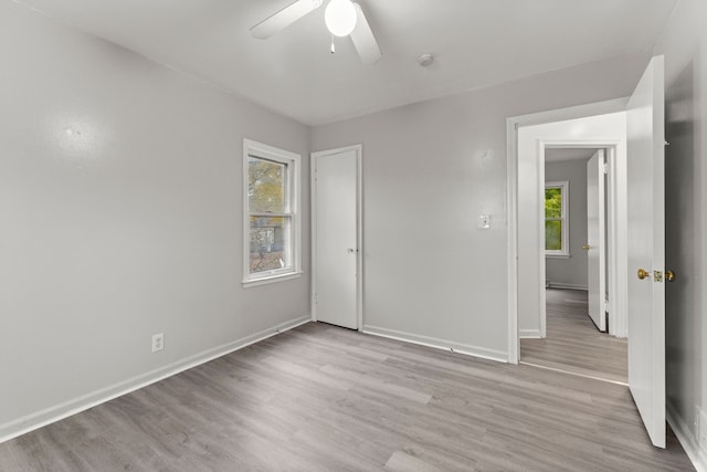 unfurnished room featuring ceiling fan, a healthy amount of sunlight, and light hardwood / wood-style flooring