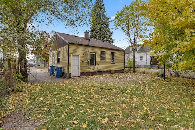 rear view of house featuring a lawn