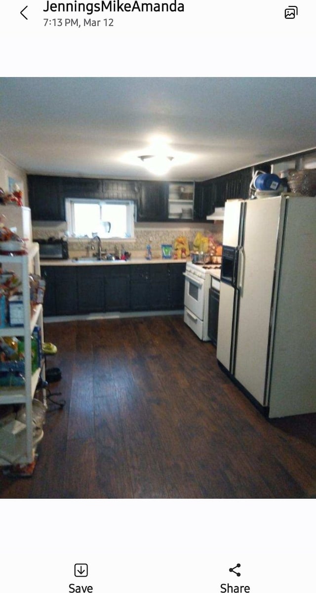 kitchen featuring white appliances, dark wood-type flooring, sink, tasteful backsplash, and extractor fan