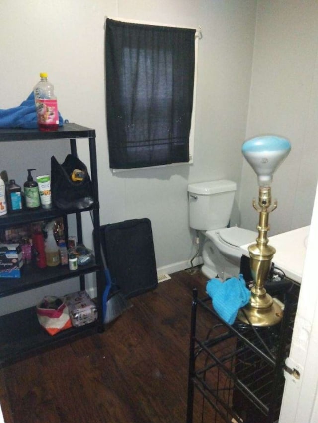 interior space featuring wood-type flooring and toilet