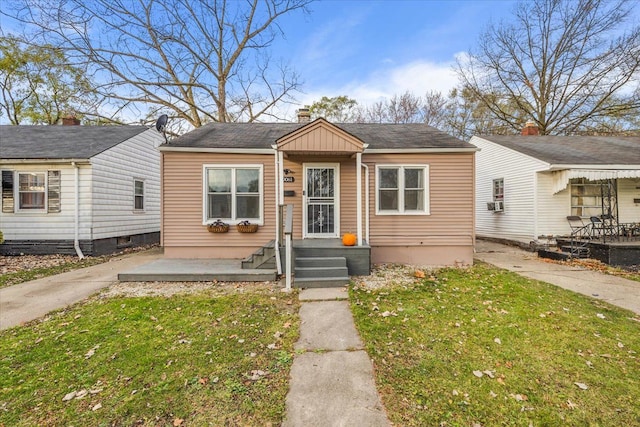 bungalow-style home featuring a front lawn and cooling unit