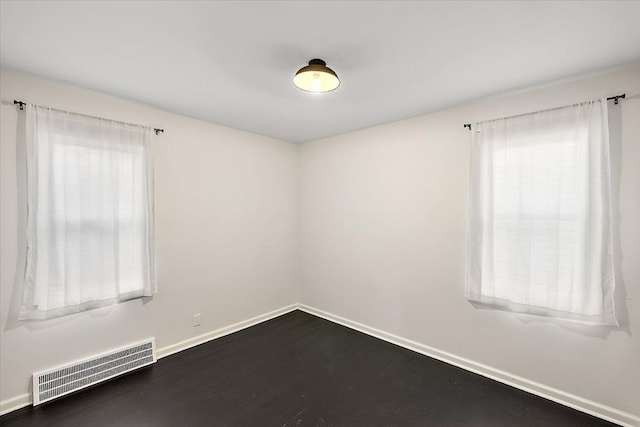 unfurnished room with dark wood-type flooring