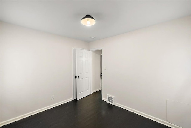 unfurnished room featuring dark wood-type flooring