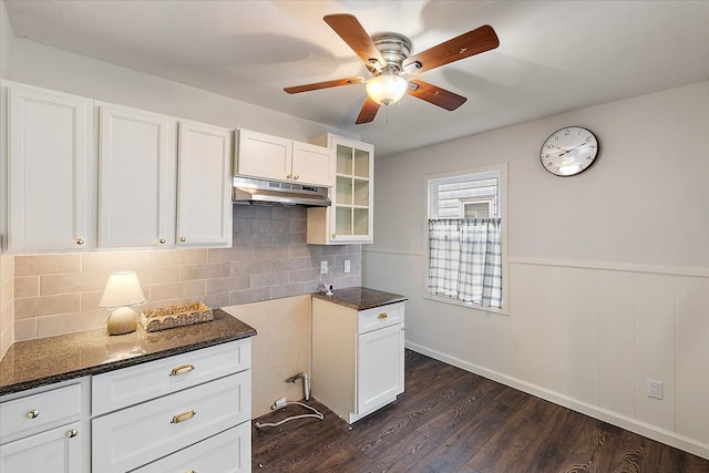 kitchen featuring dark stone counters, white cabinets, dark hardwood / wood-style floors, ceiling fan, and decorative backsplash