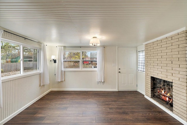 unfurnished living room with a fireplace, plenty of natural light, and dark hardwood / wood-style floors