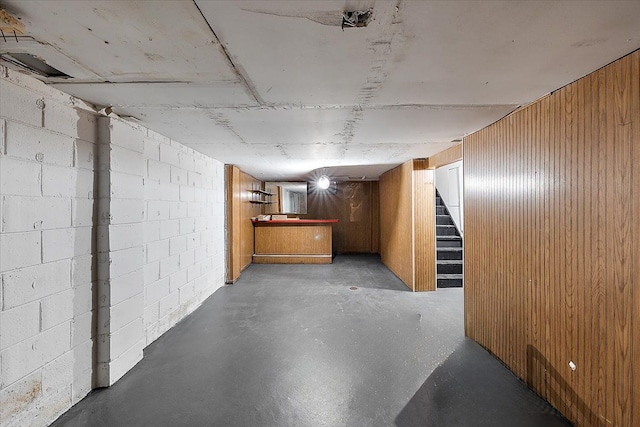 basement featuring wooden walls