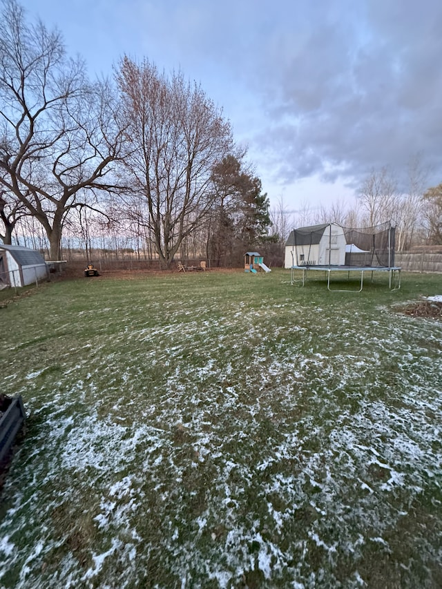 view of yard featuring a playground and a trampoline