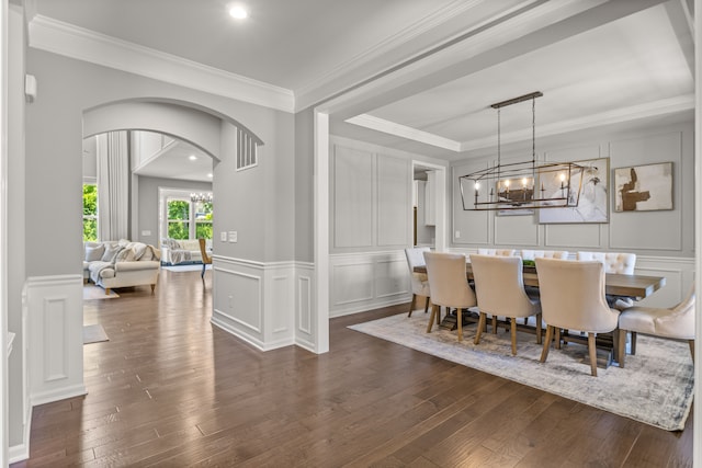 dining area with dark hardwood / wood-style flooring, crown molding, and a notable chandelier