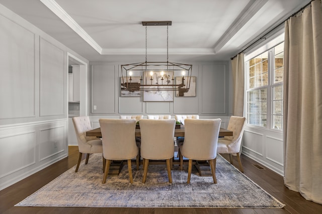 dining area with an inviting chandelier, dark hardwood / wood-style floors, a raised ceiling, and a wealth of natural light