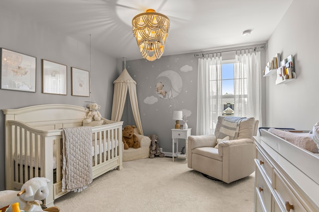 bedroom featuring a chandelier, light colored carpet, and a nursery area