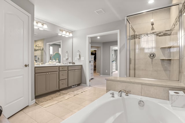 bathroom with tile patterned floors, vanity, and shower with separate bathtub