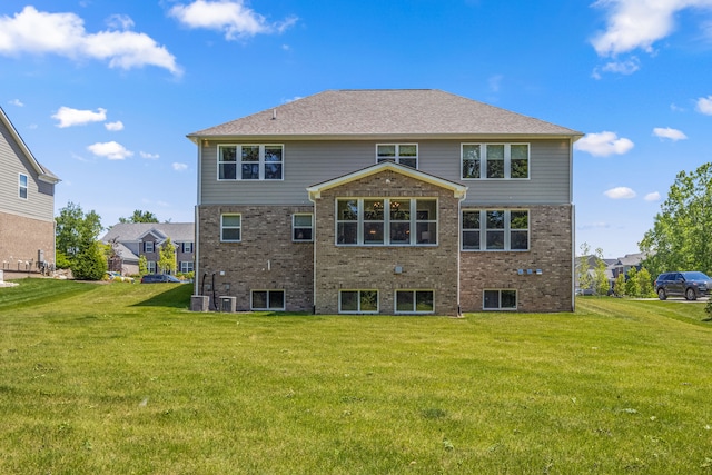 rear view of property featuring a yard and central AC unit