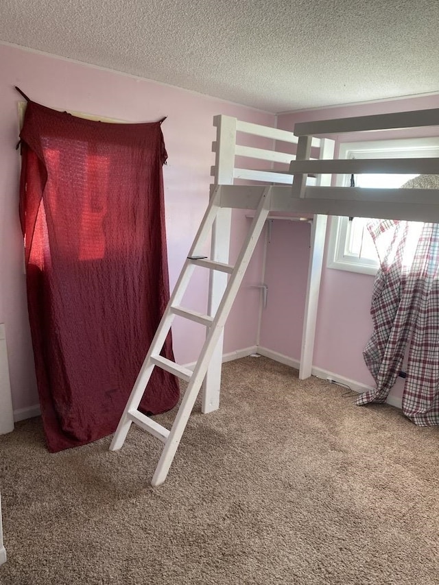 unfurnished bedroom with a textured ceiling and carpet floors