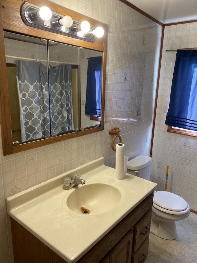 bathroom featuring vanity, tile patterned flooring, toilet, tile walls, and tasteful backsplash