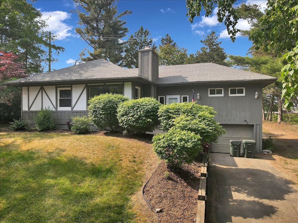 back of property featuring a yard and a garage