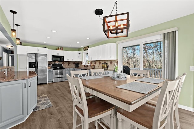 dining area featuring dark hardwood / wood-style flooring, an inviting chandelier, and sink