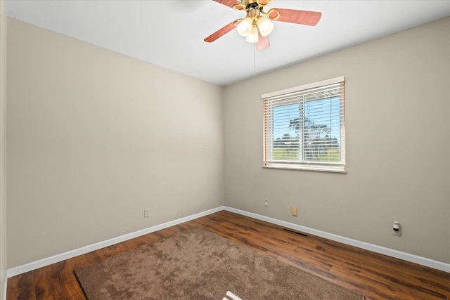 empty room with dark hardwood / wood-style flooring and ceiling fan