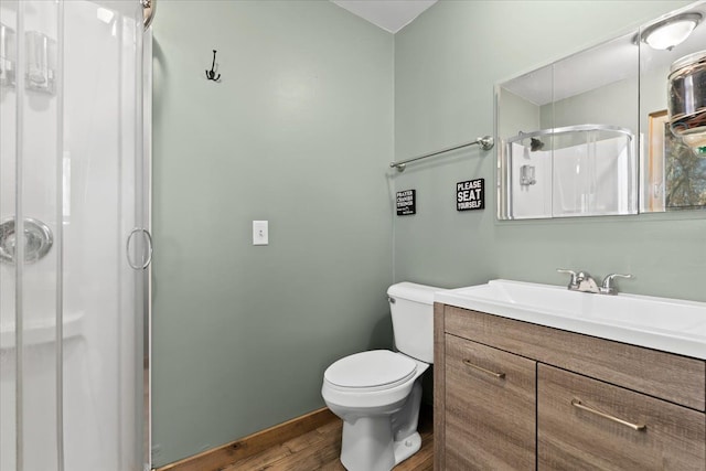 bathroom featuring hardwood / wood-style floors, vanity, toilet, and a shower with shower door