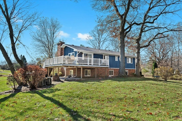 rear view of house featuring a yard and a wooden deck