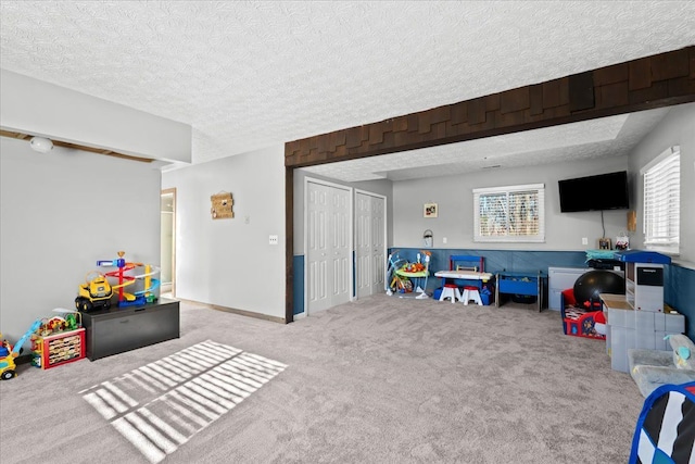 recreation room featuring carpet and a textured ceiling