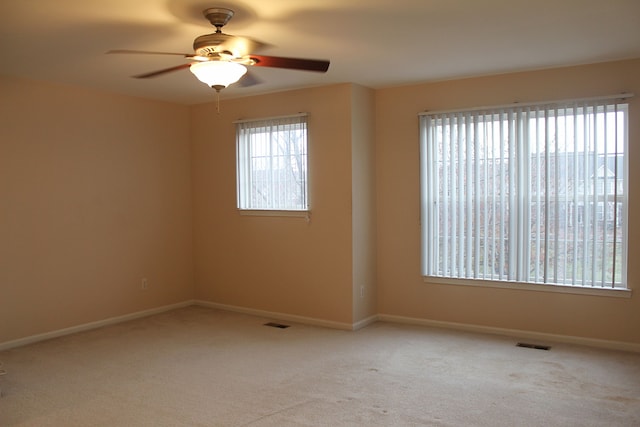 carpeted spare room featuring ceiling fan