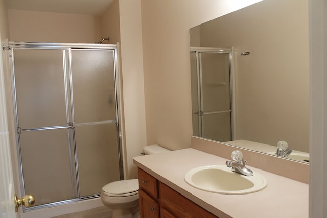 bathroom featuring walk in shower, tile patterned floors, vanity, and toilet