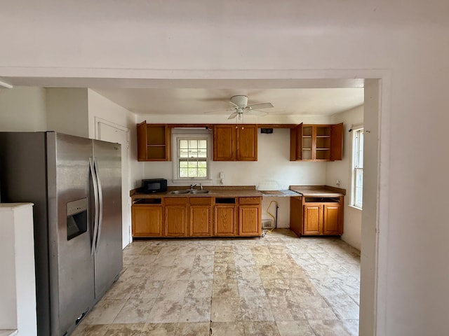 kitchen featuring stainless steel refrigerator with ice dispenser, ceiling fan, and sink