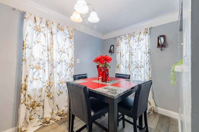 dining area featuring light hardwood / wood-style floors and an inviting chandelier