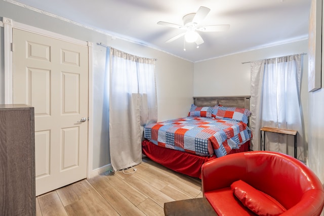 bedroom featuring ceiling fan, light hardwood / wood-style floors, and ornamental molding