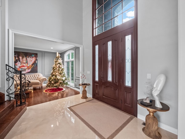 foyer with hardwood / wood-style floors and a towering ceiling