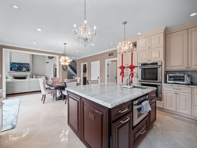 kitchen featuring backsplash, hanging light fixtures, double oven, cream cabinetry, and dark brown cabinetry