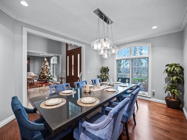 dining area with dark hardwood / wood-style flooring, a chandelier, and ornamental molding