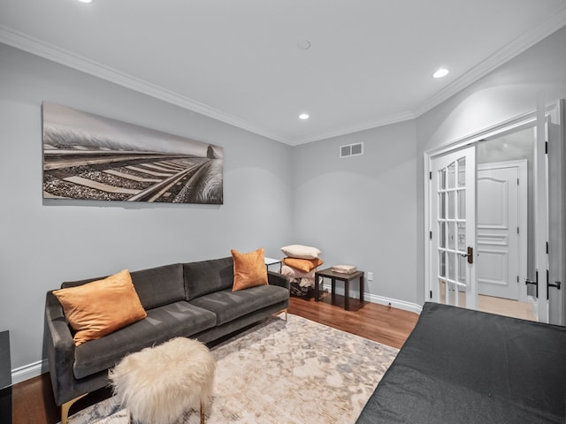 living room with wood-type flooring and ornamental molding